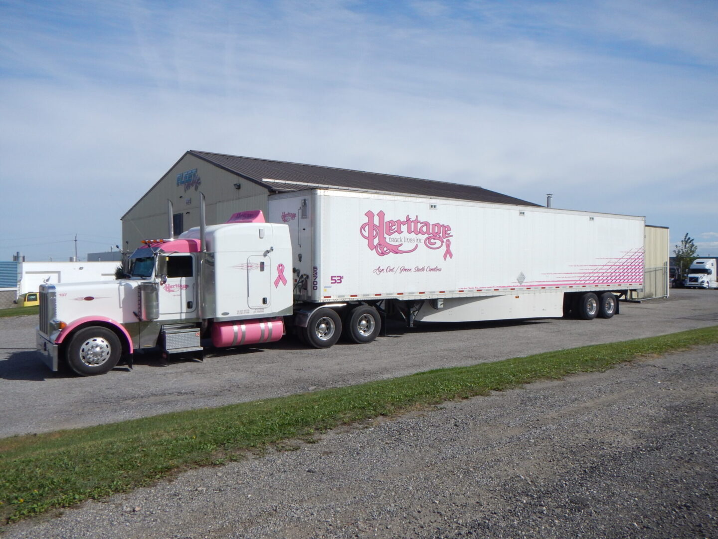 Heritage Truck Lines Inc. white and pink truck